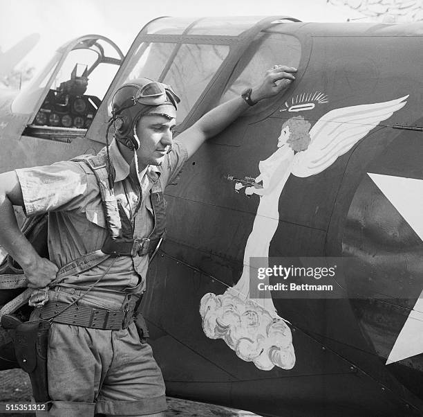 Australia- A streamlined angel with a halo and a tommy gun is painted on the plane of a U.S. Fighter pilot named Angel stationed "somewhere in...