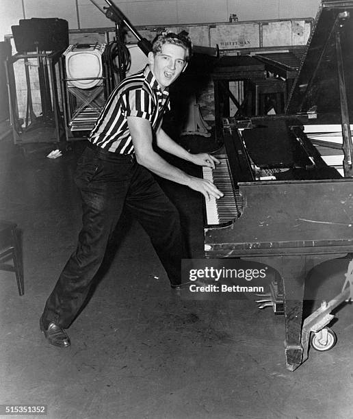 Portrait of rock-and-roll recording artist Jerry Lee Lewis. He is shown full-length, playing piano.