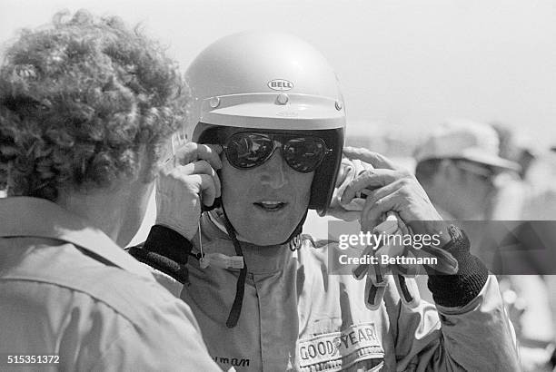 Sebring, FL- Actor Paul Newman is shown at the Annual Sebring Road Race, outside in his pit. He is taking off his helmet after qualifying his Porsche...