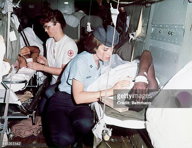 Nurses attend to wounded American soldiers as they prepare to depart from Tan Son Nhat air base for the United States.