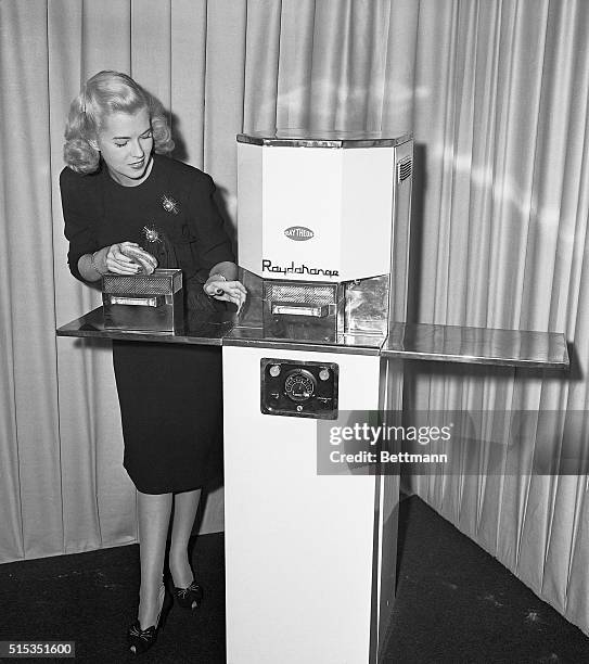 Jackie Copeland demonstrates the Raytheon Radarange's hamburger cooking abilities, on October 7 at the Waldorf-Astoria Hotel. The Radarange was a...