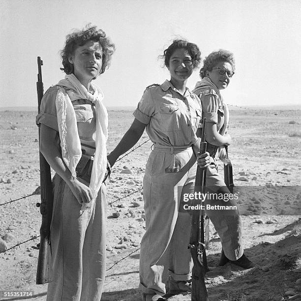 Abu Agheila, Sinai Peninsula-: Armed Israeli women soldiers pose proudly in front of a barbed wire barricade in the Abu Agheila sector after the...