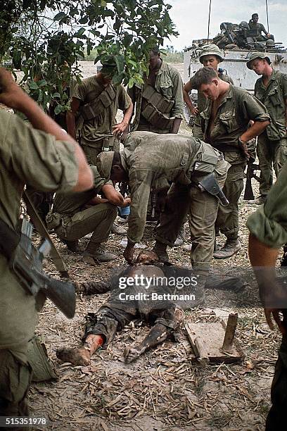 Cu Chi, South Vietnam- Twenty-fifth Infantry Division soldiers surround a Vietnamese youngster killed during fighting near Cu Chi.