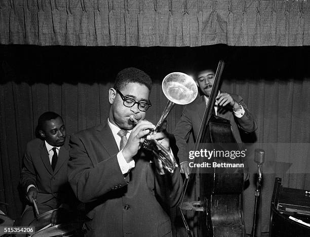Jazz legend Dizzy Gillespie playing the trumpet with two other band members in 1955.