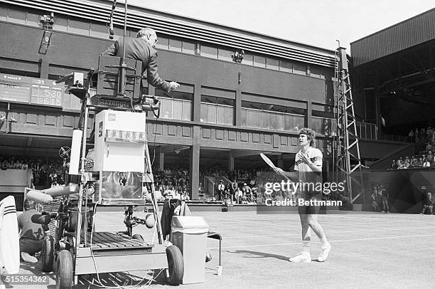 Wimbledon, England: John McEnroe is shown approaching the umpire to contest a call. He went on to argue with the ump, attempt to break his racket in...