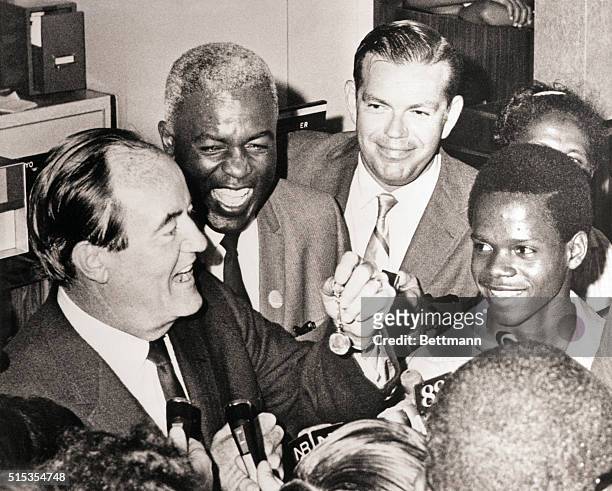 New York, NY- Vice-President Hubert H. Humphrey, campaigning in Harlem to accept the endorsement of Jackie Robinson , displays a silver dollar key...