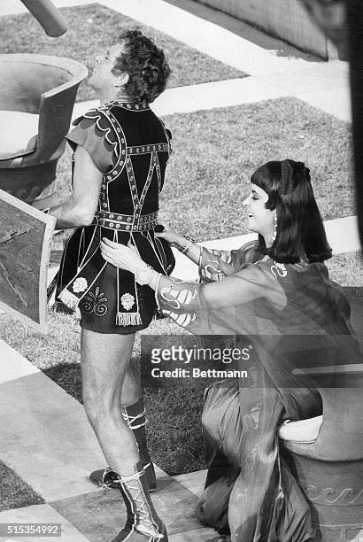 Elizabeth Taylor adjusts Richard Burton's costume on the the set of Cleopatra.