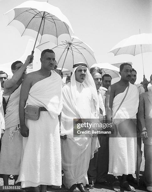 Colonel Gamal Abdel Nasser , Prime Minister of Egypt, is sheltered by an umbrella as he arrives in Mecca for a visit with Saudi Arabian leader Ibn...