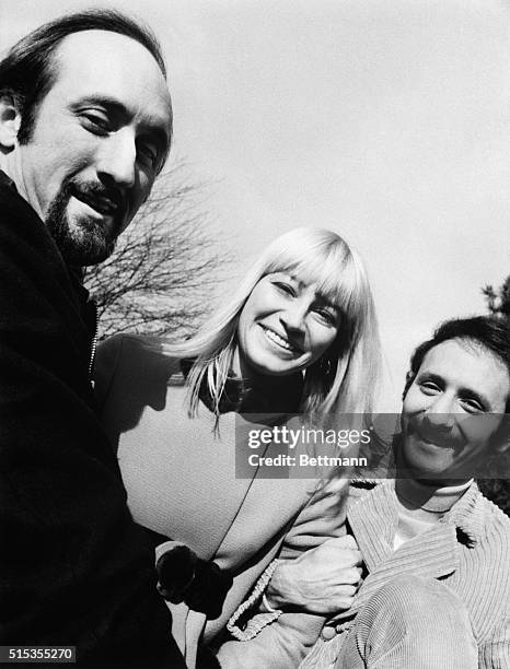 Picture shows Peter, Paul, and Mary singing group. Paul Stookey, Mary Travers, Peter Yarrow. Image shows members of the group standing outdoors.