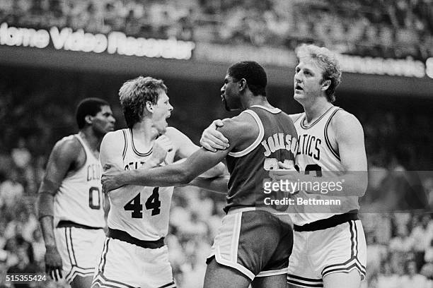 Boston Celtics' basketball player Larry Bird restraining Los Angeles Lakers' Magic Johnson from punching Celtics' Danny Ainge. Tempers flared during...