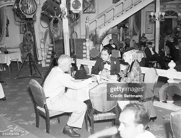 Director Howard Hawkes, Eddie G. Robinson, and Miriam Hopkins are shown on the set depicting the inerior of the "Bella Union" famous gambling house...