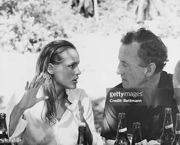 James Bond creator Ian Fleming chats with actress Ursula Andress between scenes of the upcoming action spy film, Dr. No. The Swiss actress is...