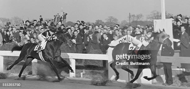 Seabiscuit, ridden by George Woolf, surges past the finish line at Pimlico Race Course. War Admiral, ridden by Charlie Kurtsinger, is almost a full...