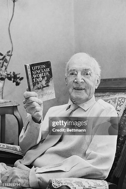 Muckraking author and journalist Upton Sinclair, author of The Jungle, in his home with a copy of his novel World's End.