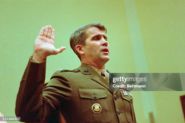 Washington DC: John Poindexter takes the oath before the House Foreign Affairs Committee; took the fifth on Iran Contra.