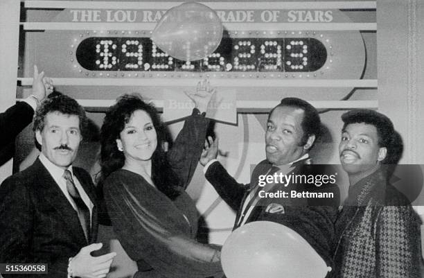 Hollywood: Alex Trebek, Jayne Kennedy, Lou Rawls and LeVar Burton point with pride to the tote board of the seventh annual "Lou Rawls Parade of...