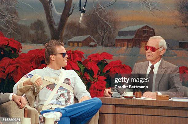 Burbank, Calif.: Talk show host Johnny Carson models a pair of red sunglasses given to him by Jim McMahon as the Chicago Bears quarterback appears on...