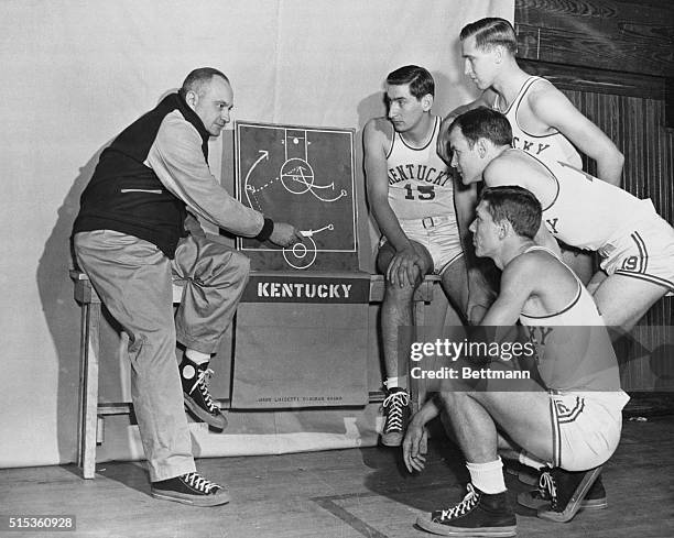 Members of the University of Kentucky basketball team, left to right, Alex Groza, Jim Jordan, Jack Parkinson, and Ralph Beard, listen to coach Adolph...