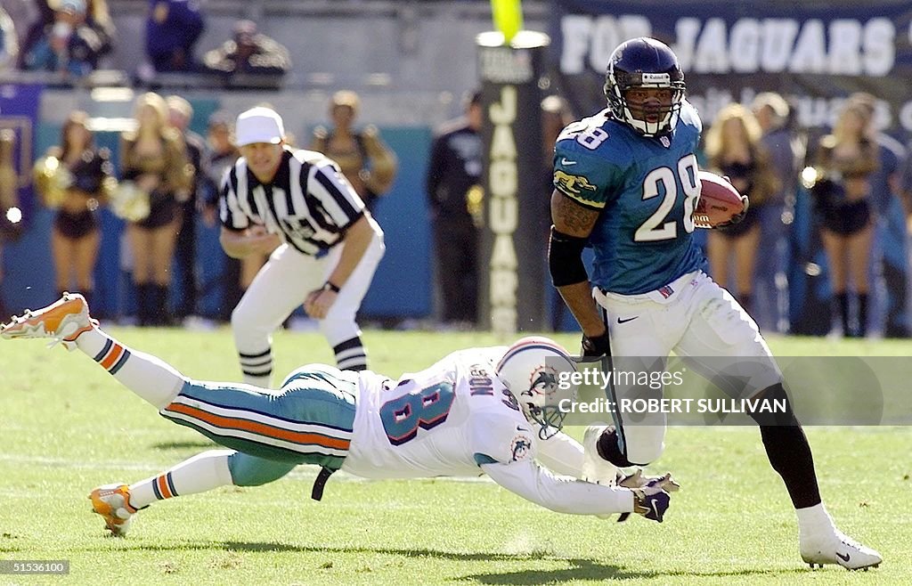 Fred Taylor (R) of the Jacksonville Jaguars runs p