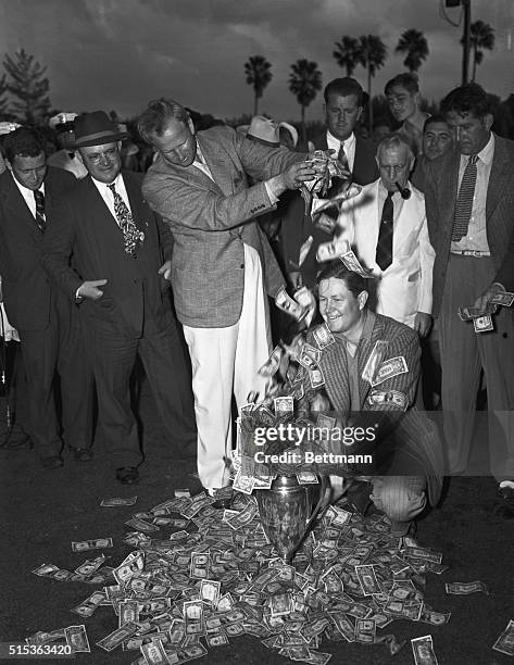 Clayton Heafner, of Linville, North Carolina, runner in the Miami Open Golf tourney showers $2,500 one-dollar bills upon Byron Nelson, of Toledo,...