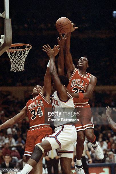 Knicks' Jerrod Mustaf is caught in the middle between Chicago Bulls' #34 Stacy King and Michael Jordan as Michael Jordan blocks his shot at the...