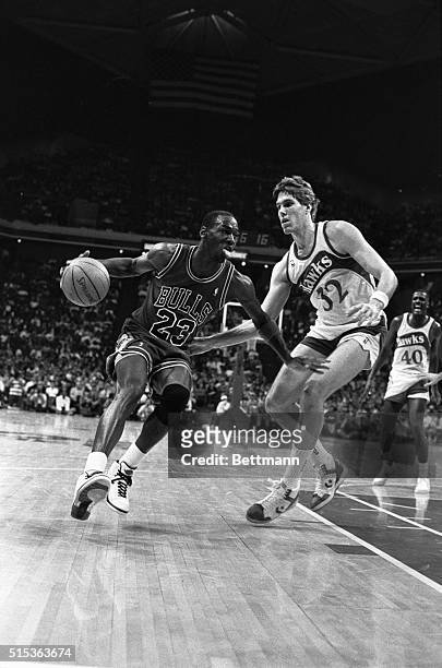 Michael Jordan of the Bulls leans his shoulder into the defending Jon Koneck of the hawks during first quarter action 3/9.