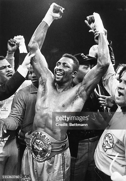 Detroit, MI: Fists raised in jubilation, Thomas "Hit Man" Hearns wears his newly won title belt after defeating Britain's Dennis Andries with a TKO...
