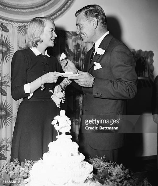 Screen actor Clark Gable and his bride, the former lady Sylvia Stanley, widow of Douglas Fairbanks, Sr., sample their wedding cake following wedding...