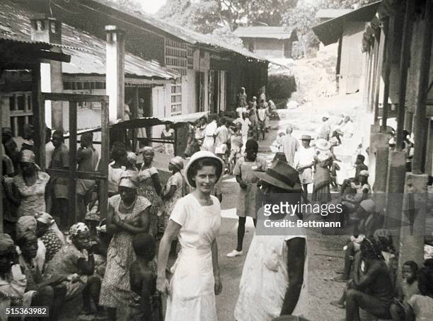 Albert Schweitzer's medical mission in Lambarene, equatorial Africa. Nurse Albertina with orderly and group of patients waiting for treatment.