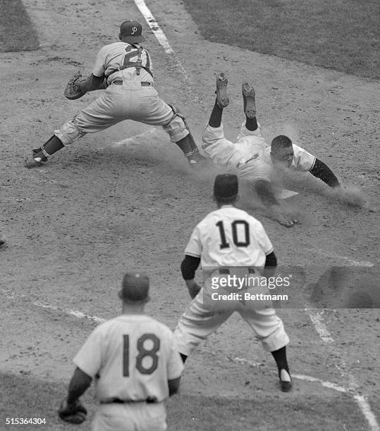 Willie Mays of the New York Giants dives into home plate safely here in the sixth inning of the Giants-Philadelphia Phillies game at the Polo...