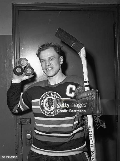 Wing's Bill Mosienko of the Chicago Black Hawks holds up three pucks here, signifying the new National Hockey League record he made on March 23 by...
