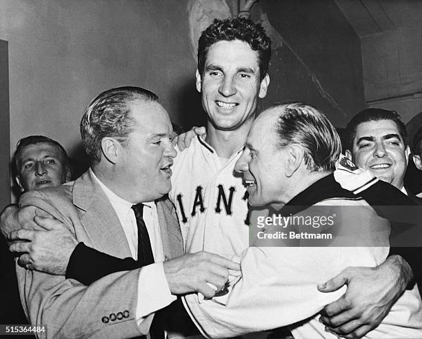 Horace Stoneham owner of the miracle" club, and New York Giant's manager Leo Durocher hug Bobby Thomson in the dressing room after the Giants' third...
