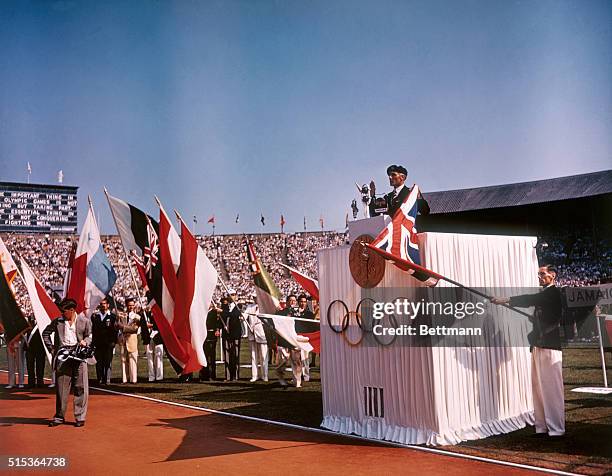 Wing Commander Donald Finlay, British Hurdler, taking the Olympic Oath from the Rostrum during the official opening of the XIV Olympiad at Wembley...