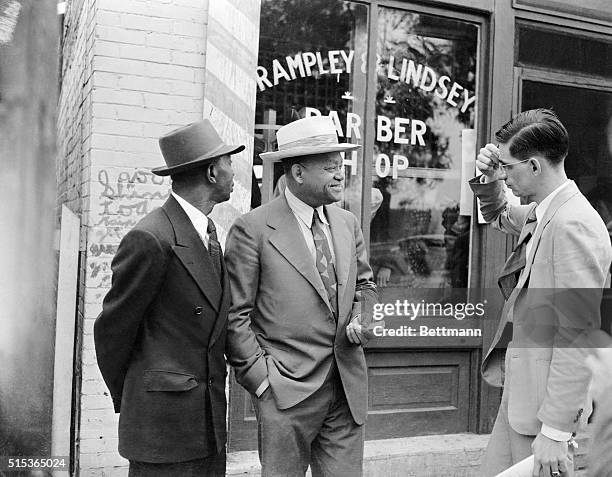 Walden, attorney for Atlanta Beach, engages in a conversation with an unidentified man outside of a barbershop.