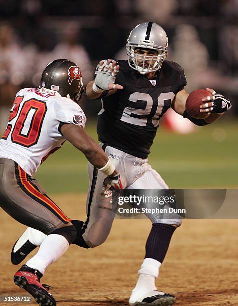 Justin Fargas of the Oakland Raiders runs with the ball against Ronde Barber of the Tampa Bay Buccaneers on September 26, 2004 at Network Associates...