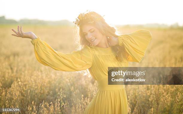 happy woman in fields with sunlight - yellow dress stock pictures, royalty-free photos & images