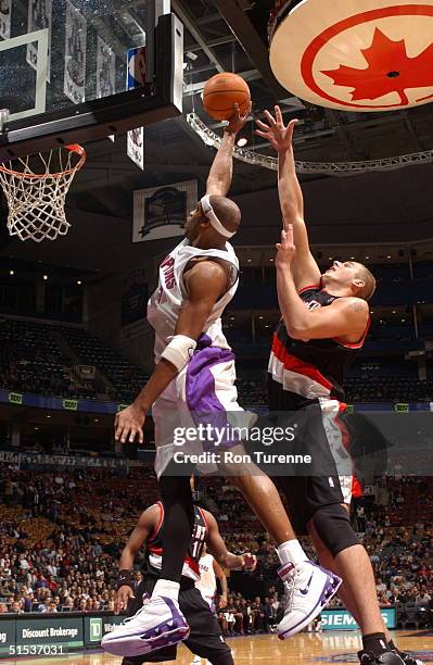 Vince Carter of the Toronto Raptors soars along the baseline ahead of Joel Przybilla of the Portland Trailblazers on October 21, 2004 at the Air...