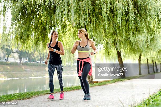 femmes rapidement à pied dans le parc - marche sportive photos et images de collection