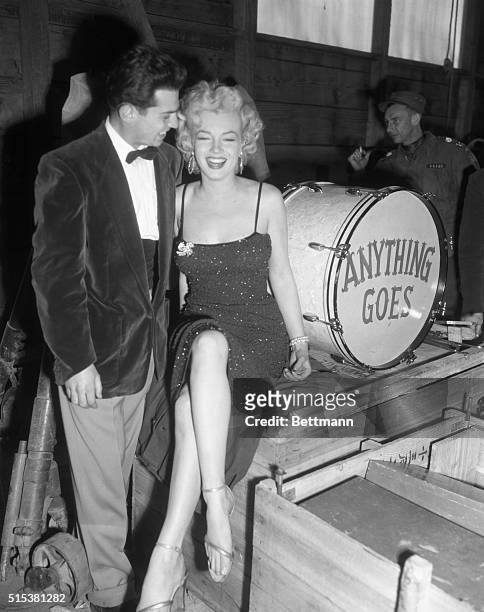Marilyn Monroe laughs at the on-stage quip of Cpl. Al Guastafeste, of Uniondale, L.I., who led the five piece band that played during her Korea...