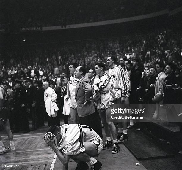 Boston Celtics' rookie Tom Heinsohn can't bear to look at the final seconds of action while coach Red Auerback watches the clock during a National...