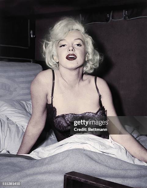 Marilyn Monroe poses in a bed wearing sexy lingerie during the shooting of her film, Some Like It Hot.