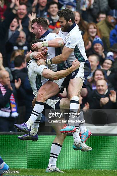 Duncan Taylor of Scotland is congratulated by teammates Stuart Hogg and Tommy Seymour of Scotland after scoring his team's second try during the RBS...
