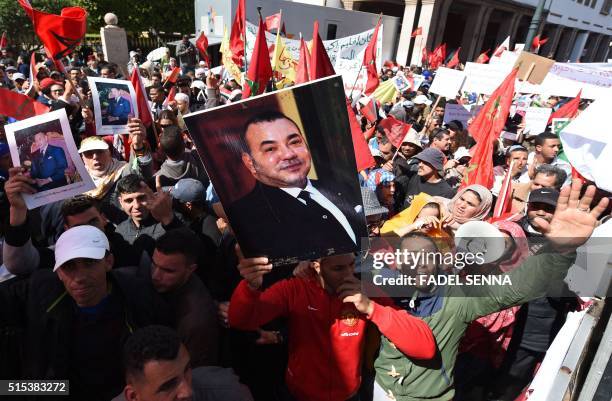 Moroccan protesters hold placards depicting portraits of their king, in the capital Rabat, on March 13 during a demonstration against statements made...