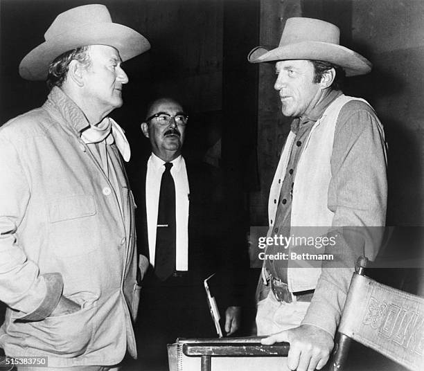 Two big western stars meet again as "Gunsmoke" star Jim Arness stopped by to visit his old friend John Wayne. During the visit on the set of Wayne's...