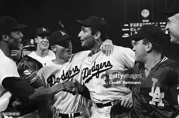 Los Angeles, CA: Dodger pitcher Sandy Koufax is mobbed by teammates on the field after pitching a perfect game. Shown in the picture are : Willie...