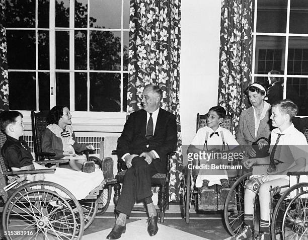 President and Mrs. Roosevelt enjoying after-luncheon conversation with little patients of the Warm Springs Foundation.