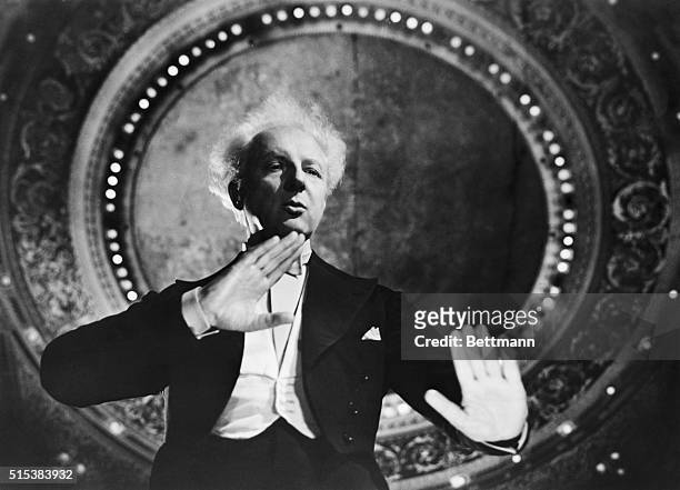 Leopold Stokowski, , American conductor, during a performance. Half-length photograph taken from the orchestra pit, ca. 1950.