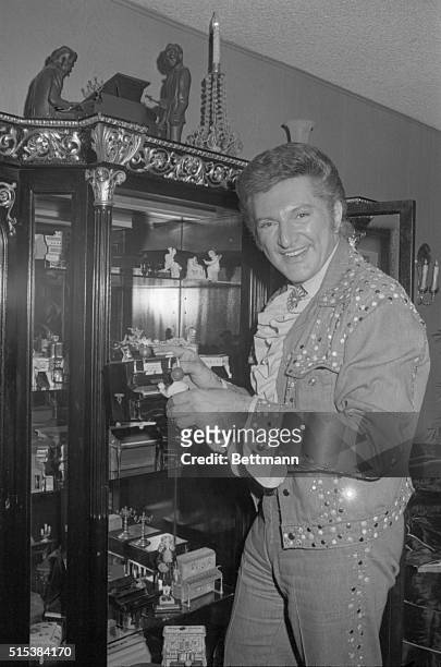 Famous pianist Liberace listens as one of his young protégés, Vince Cardell, plays the piano during a press preview of Liberace's' Museum, formerly...