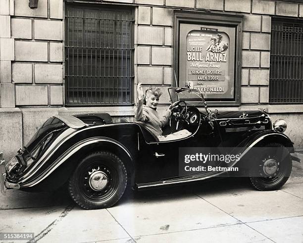 Film Actress Lucille Ball tries out the first British "Singer" sports roadster to be flown to the West Coast. Miss Ball helped comedian Jerry Lewis,...