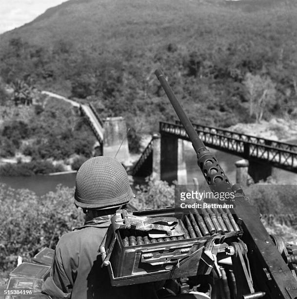 Taking the high ground, Royal Laotian troops on an armored vehicle pull up into a position overlooking a blown-up bridge on the Nam Lik River, near...